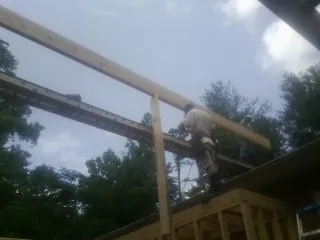 Carpenter setting a ridge beam over a new addition frame — Ice Dam Removal by Roofing Brothers in Ellaville