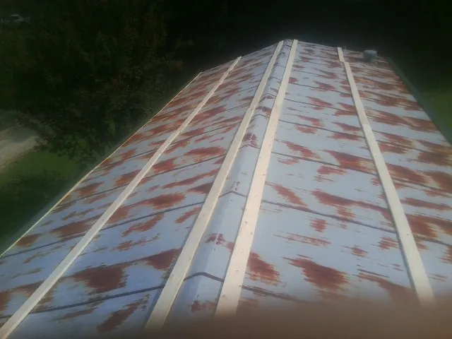 Rusted metal roof panels with new wood purlins before replacement — Storm Damage Roof Repair in Ellaville by Roofing Brothers